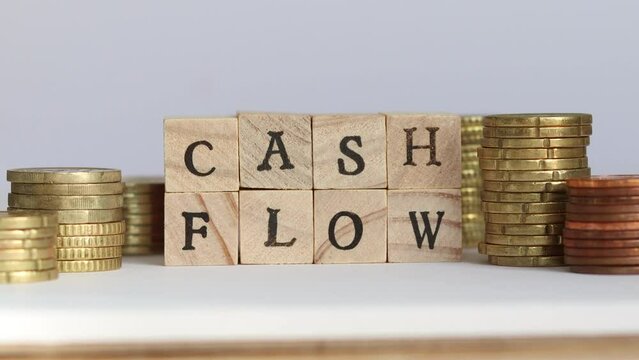 Stop motion video of the words "cash flow" spelling while stacks of coin pile up