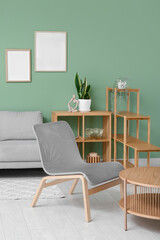 Stylish interior of modern living room with blank picture frames on color wall