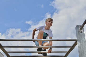 boy on the horizontal bar at the playground