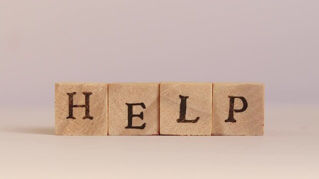 Hands drop down block letters and spell the word HELP
