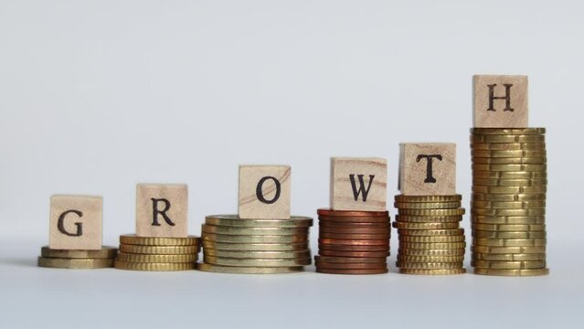 Stop motion video of  coins stacking up and block letters forming the word GROWTH