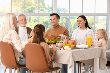 Happy family having dinner at festive table on Thanksgiving Day