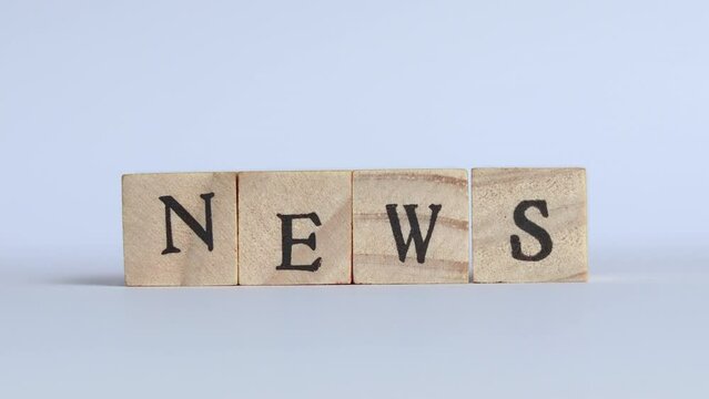Hand places a block letter S behind the word NEW forming the word NEWS