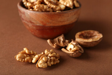 Tasty walnuts on brown background