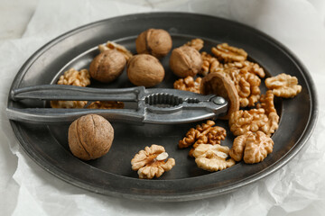 Plate of tasty walnuts on table