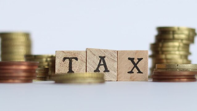 Stop motion video of coins stacking while block letters spell the word TAX