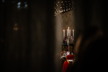 Close-up photo of chromium candlestick with five unlit white wax candles placed on the table...