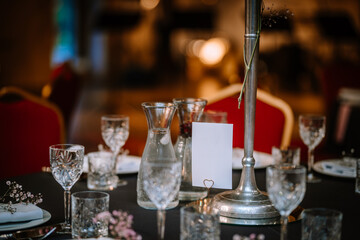 Wine glasses in the foreground. Wedding Banquet or gala dinner. The chairs and table for guests,...