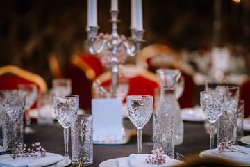 Wine glasses in the foreground. Wedding Banquet or gala dinner. The chairs and table for guests,...
