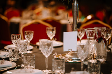 Wine glasses in the foreground. Wedding Banquet or gala dinner. The chairs and table for guests, served with cutlery and crockery.

