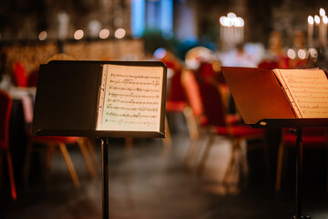 Music stands on stage in a symphony orchestra. Sheet music for a musician. The concept of culture...
