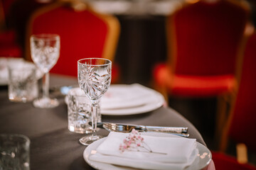 Wine glasses in the foreground. Wedding Banquet or gala dinner. The chairs and table for guests,...