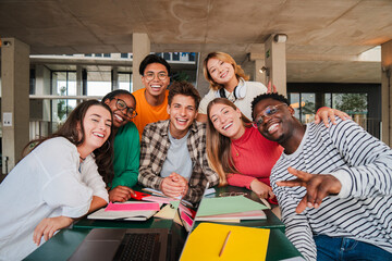 Happy young university students smiling and looking at camera enjoying together sitting in the...