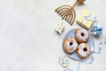 Composition with Menorah, gifts and tasty donuts for Hanukkah celebration on light background
