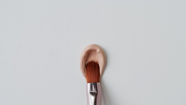 Beauty shop, Foundation face make-up close up smudge, smear. Cosmetic liquid foundation cream beige color smudge smearing. 