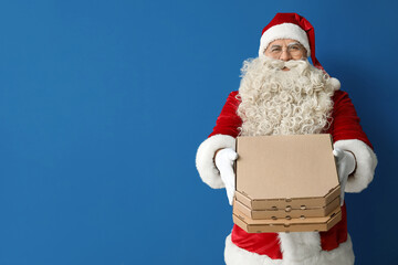 Santa Claus with pizza boxes on blue background