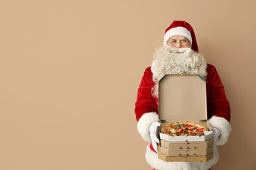 Santa Claus with boxes of tasty pizza on beige background