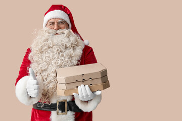 Santa Claus with pizza boxes showing thumb-up on beige background