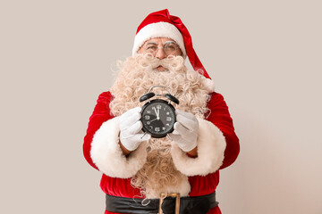 Santa Claus with alarm clock on white background