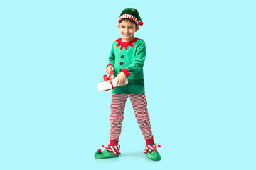 Cute little elf with Christmas gift on blue background