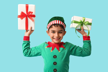 Happy little elf with Christmas gifts on blue background