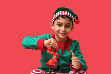 Cute little elf with Christmas bell on red background