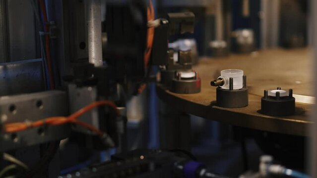 Close-up automatic industrial equipment producing plastic stub. Machines sorting components for plumbers. Industrial line. Robotics and automation. Plastic stub products processing factory. 50 fps