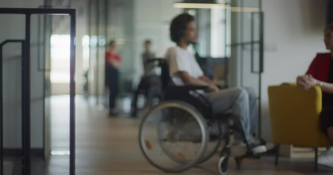 African American businessman in a wheelchair engages in a professional discussion with his colleague, addressing various business challenges and exploring solutions in an inclusive and diverse modern