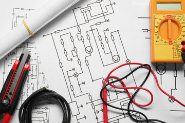 Wires and digital multimeter on wiring diagrams, top view