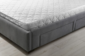 Fototapeta premium New light green mattress on gray bed indoors