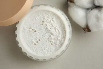 Rice loose face powder and cotton flower on light grey background, flat lay