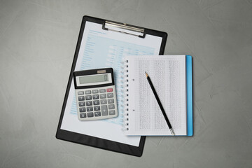 Calculator, notebook, pencil and document on grey table, flat lay