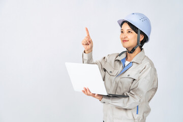 パソコンを持つヘルメットと作業服を着た女性　作業員　エンジニア　切り抜き背景透過PNG