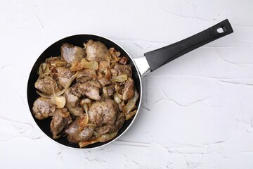 Pan with tasty fried chicken liver and onion on white textured table, top view - obrazy, fototapety, plakaty