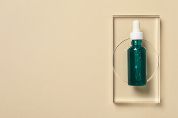 Bottle of cosmetic serum on beige background, top view. Space for text