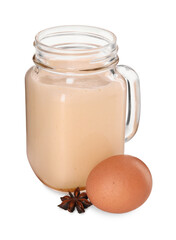 Glass mason jar of delicious eggnog with anise star and egg isolated on white