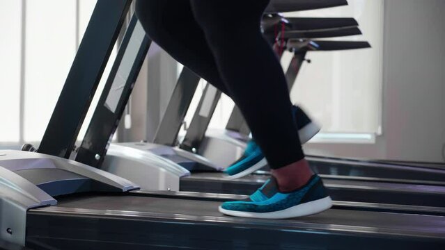 Closeup foot of young black woman workout with jogging and exercise on machine treadmill in fitness gym, woman cardio with training jogging, healthcare and motivation, female in sportswear and health.