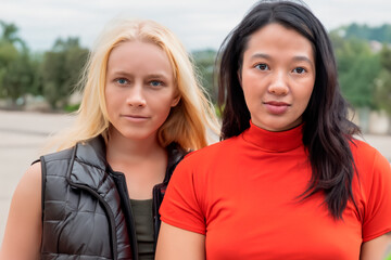 Dwie kobiety przyjaciółki, jedna z nich to blondynka z niebieskimi oczami a druga jest Chinką