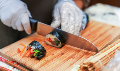 kimbap making, a cherished Korean culinary tradition. Skilled hands roll rice, vegetables, and...