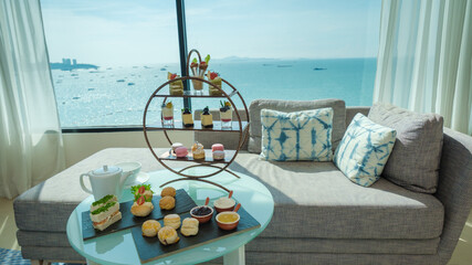 afternoon tea or high tea in a hotel room with bright fresh colors, a minimal style bedroom with an ocean view - obrazy, fototapety, plakaty