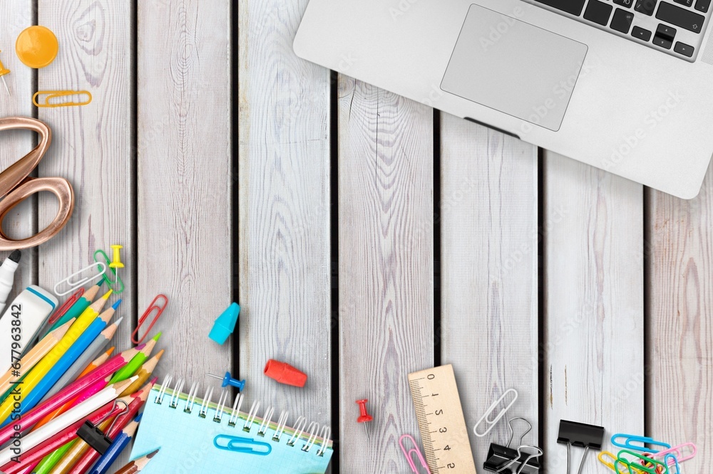 Wall mural school supplies on wooden school desk.