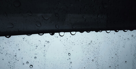 Raindrops on the edge of the car glass background. Water on the window glass.