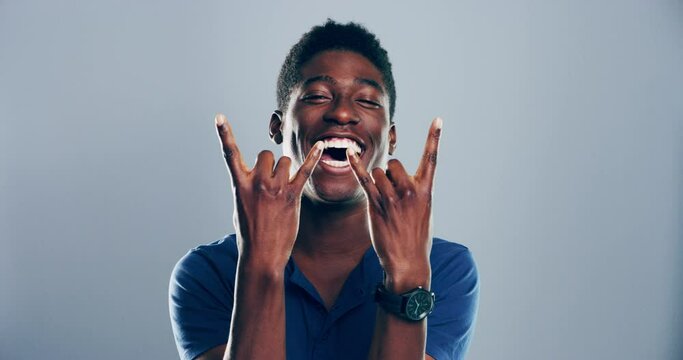 Portrait, rock and roll with black man, musician and artist with attitude on a grey studio background. Face, African person and model with heavy metal music, hand sign and freedom with punk and emoji