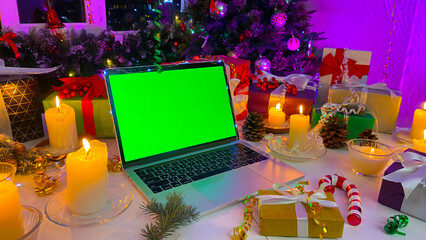 Personal computer with a chroma key on the screen lies on the New Year's table. Freelancer's...