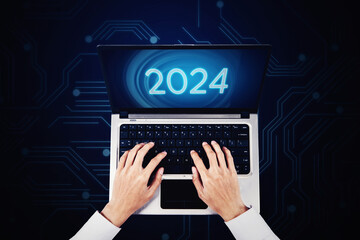 Top view of businessman hands working on laptop with number 2024 on screen