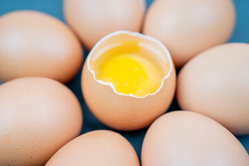 Top view closeup of eggs with one chicken egg broken with yolk