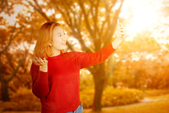 Stylish Asian woman in knit sweater captures the moment with selfie