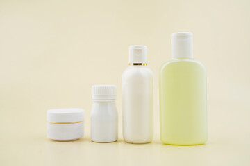 Fototapeta na wymiar Mockup of medical skin care bottles cosmetic tubes solated on cream background