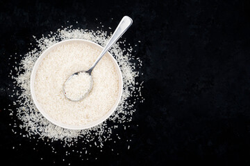 Healthy food. Bowl of white rice grains on black background