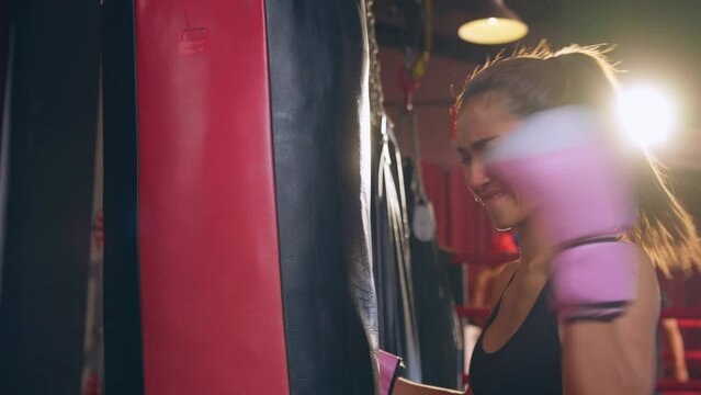 Aggressive depress athlete girl boxer doing workout in fitness stadium. 